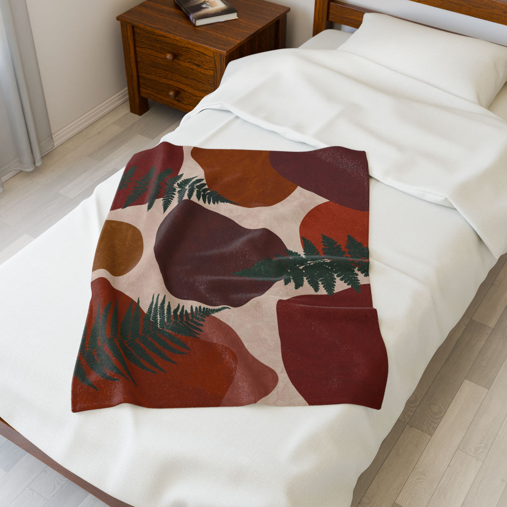Fern-patterned abstract blanket draped over a bed in a bedroom setting, boho home décor blanket