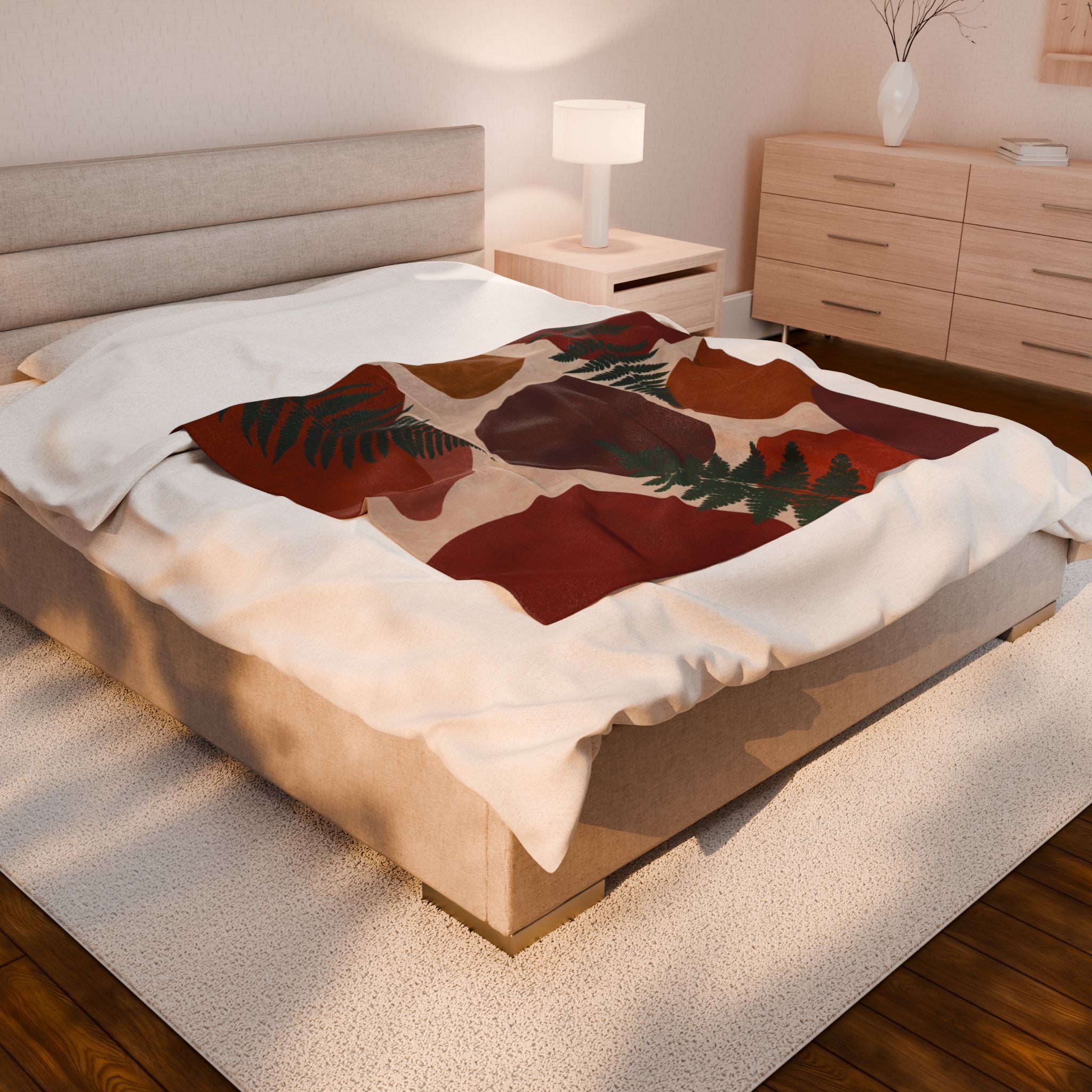 Bed with a patterned Abstract rust and cream velveteen plush blanket with green fern leaf design in a bedroom setting
