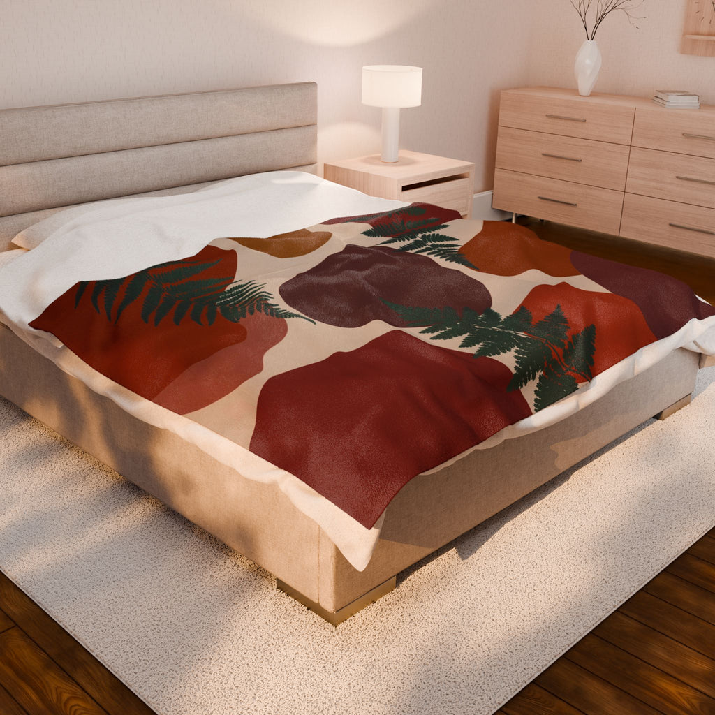 Bed with greenery patterned comforter in a bedroom setting