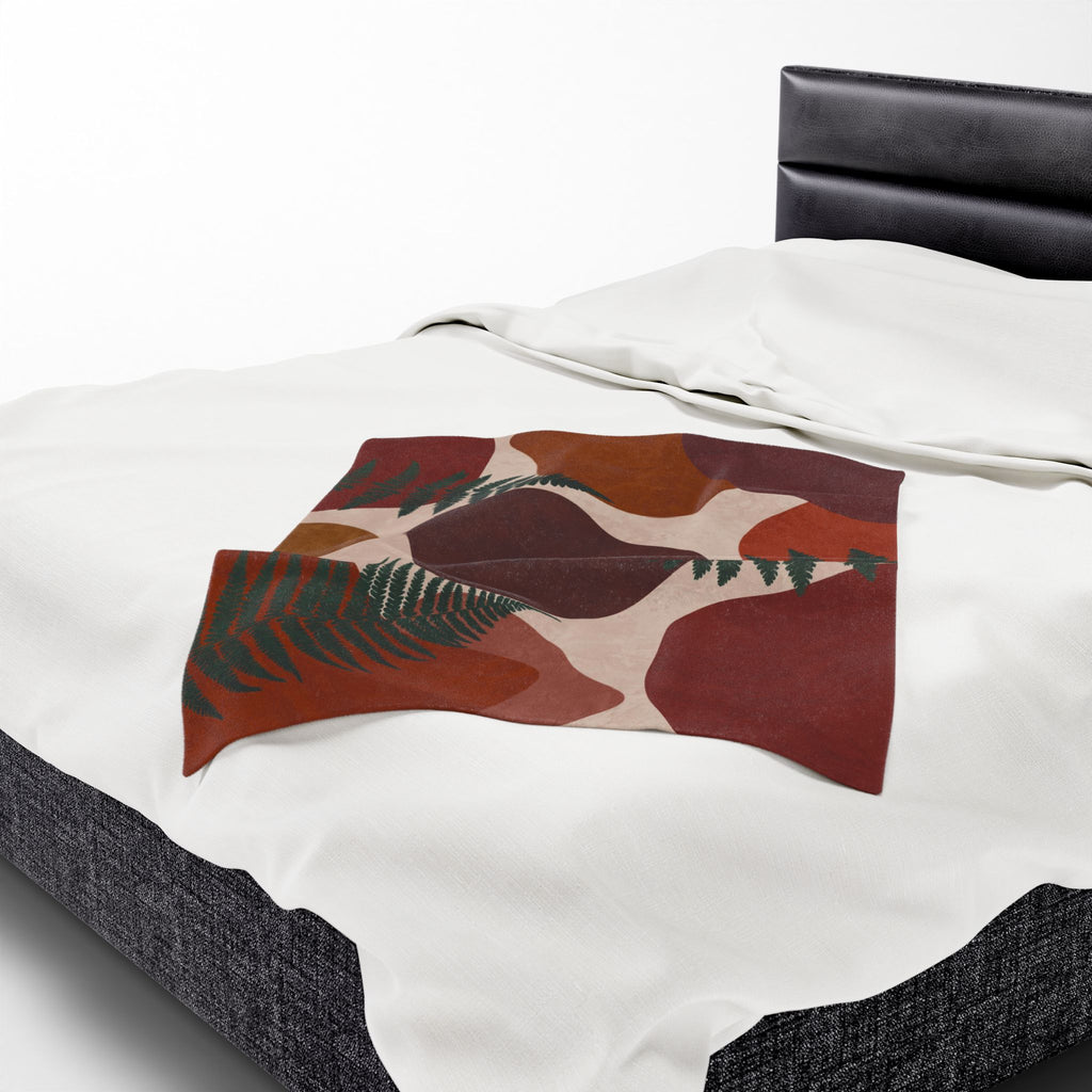 Decorative throw blanket with abstract leaf pattern on a bed
