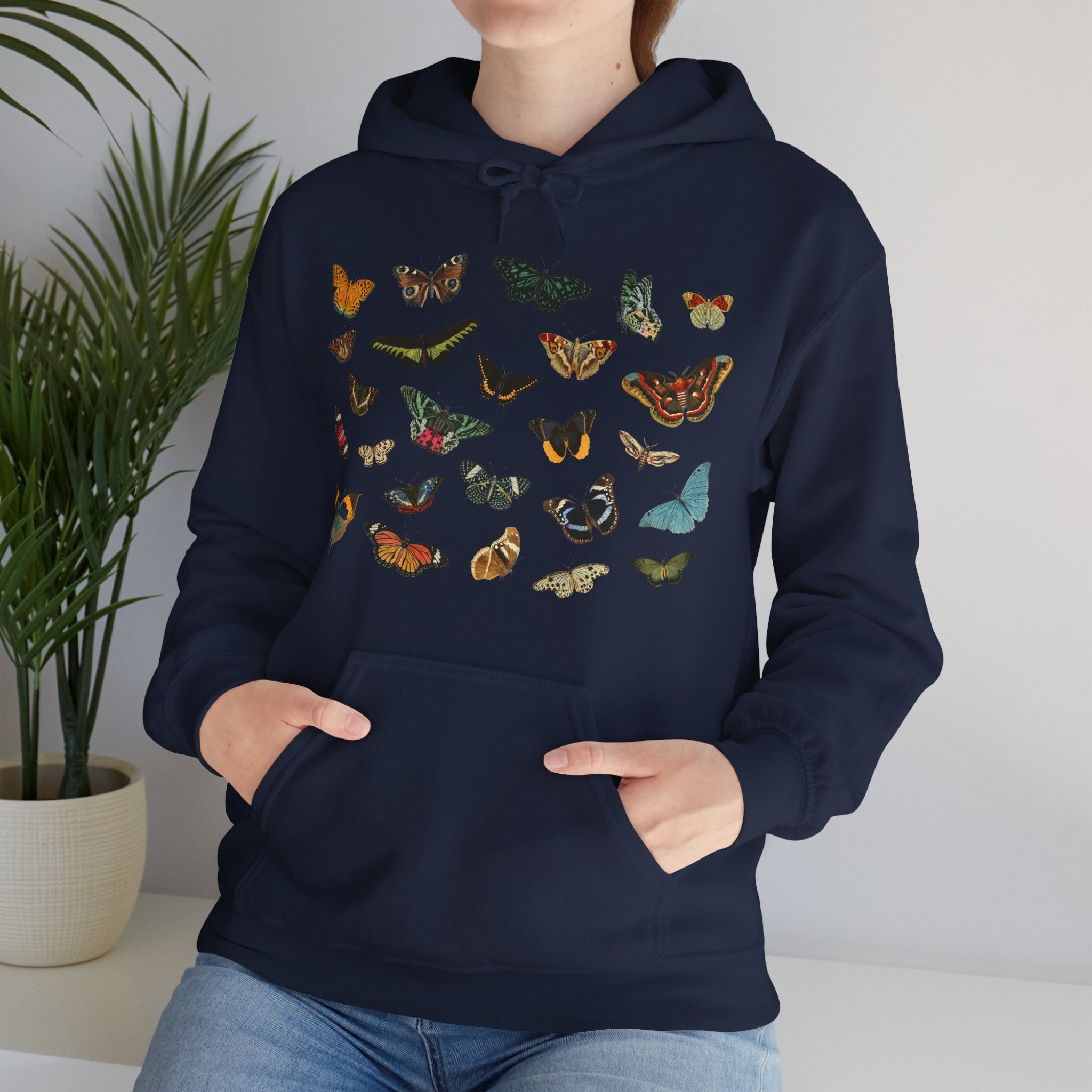 Person wearing a navy hoodie with colorful butterfly designs against a neutral background