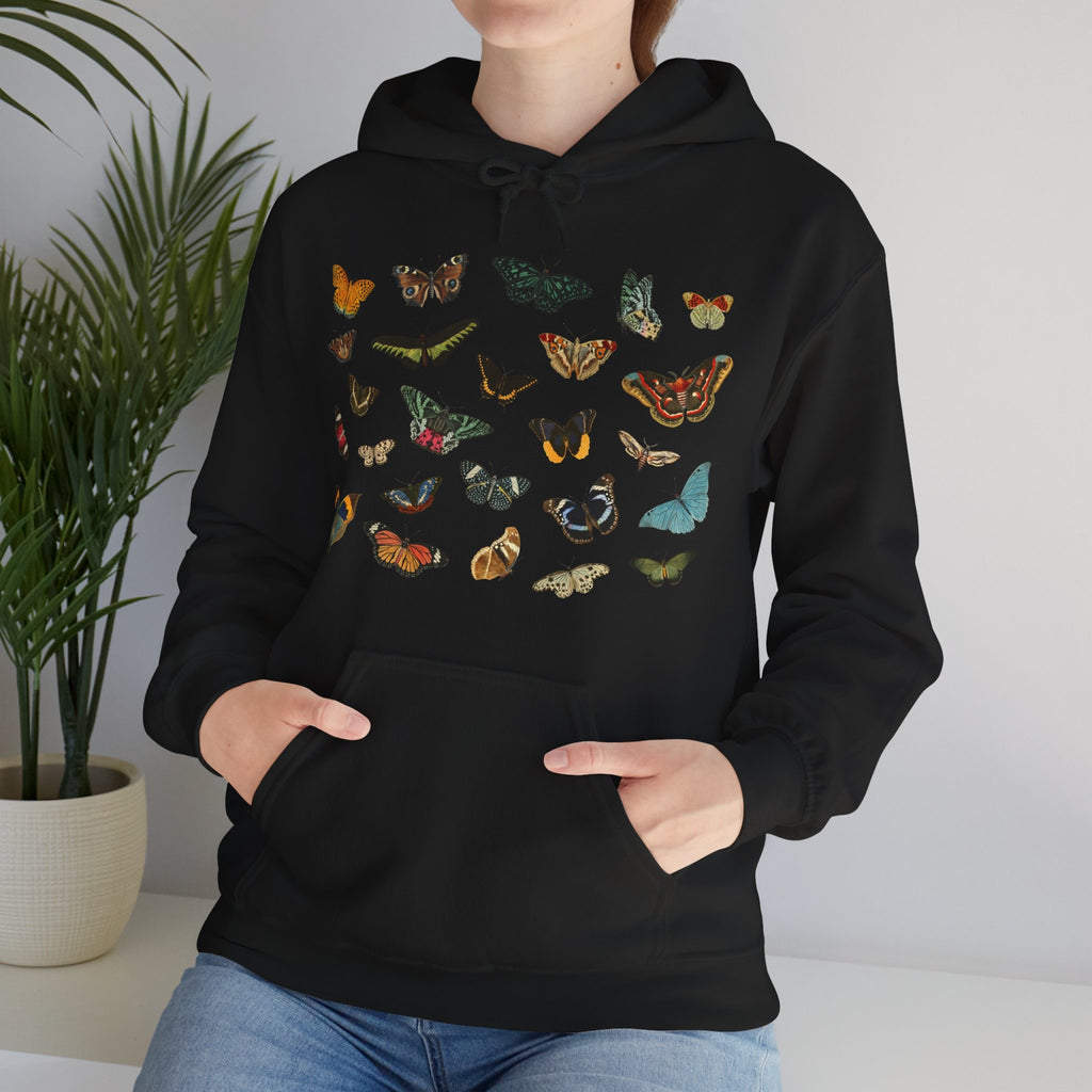 Person wearing a black Gildan hoodie with colorful butterfly & moth designs against a neutral background