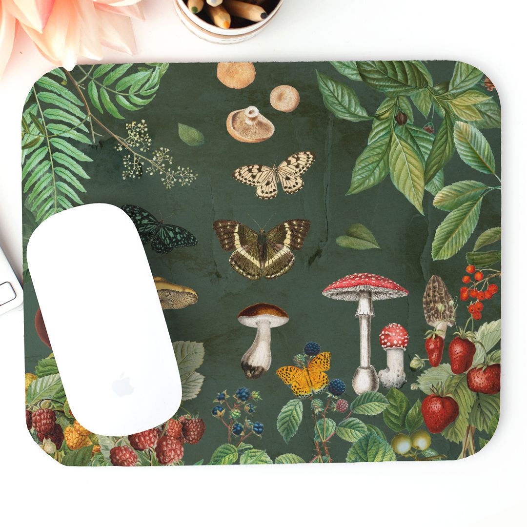 Mouse pad with nature-themed design featuring mushrooms, butterflies, and leaves on a dark green background.