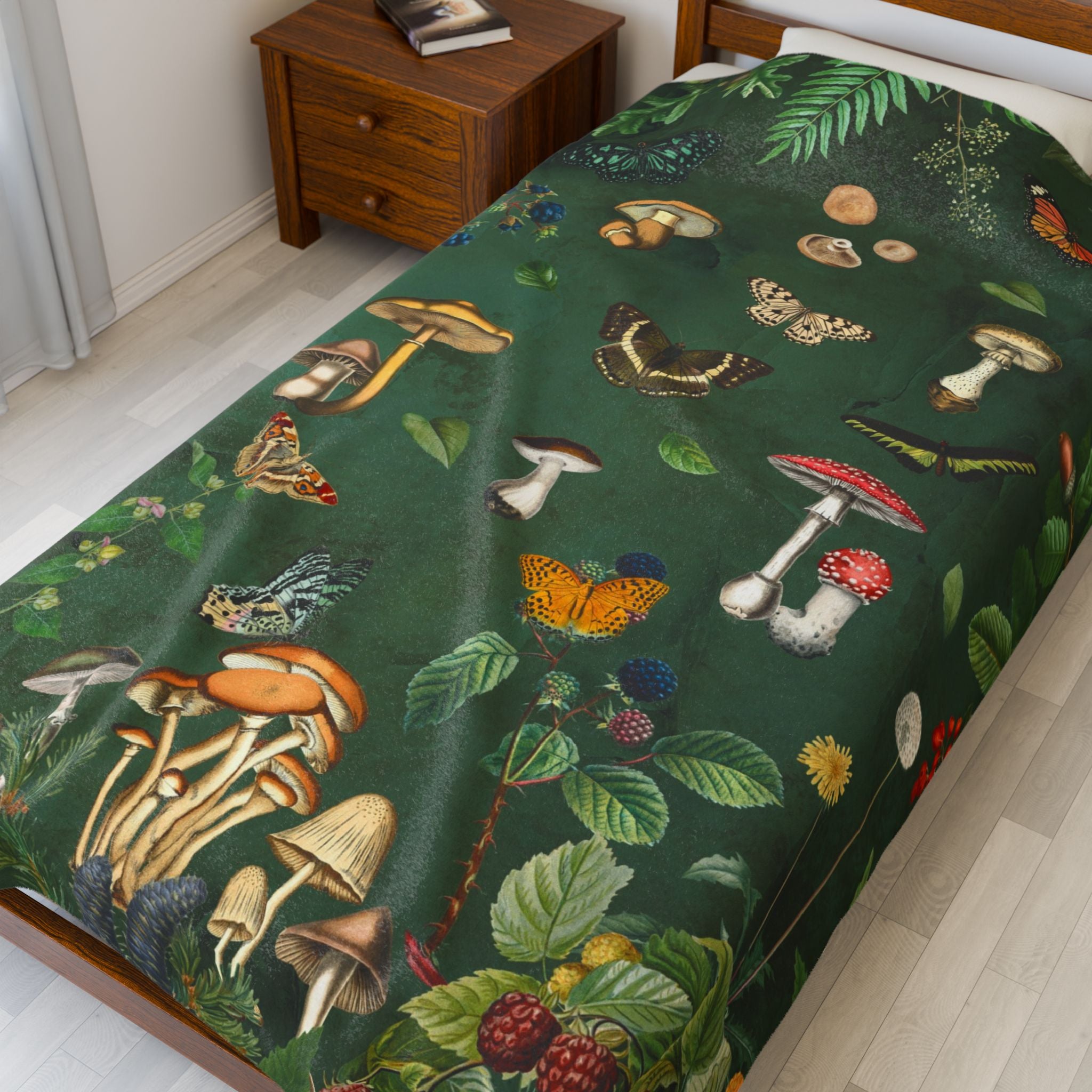 Velveteen Plush Throw Blanket with nature-themed design featuring mushrooms, butterflies, and plants on a green background.