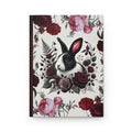 A dark academia inspired journal with deep red and pink flowers surrounding a black Dutch Rabbit.