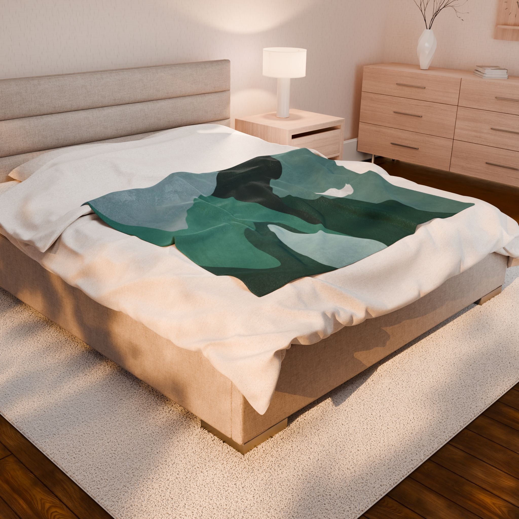 Bed with a green and teal abstract mountain design blanket in a bedroom setting. 50x60 inch velveteen blanket