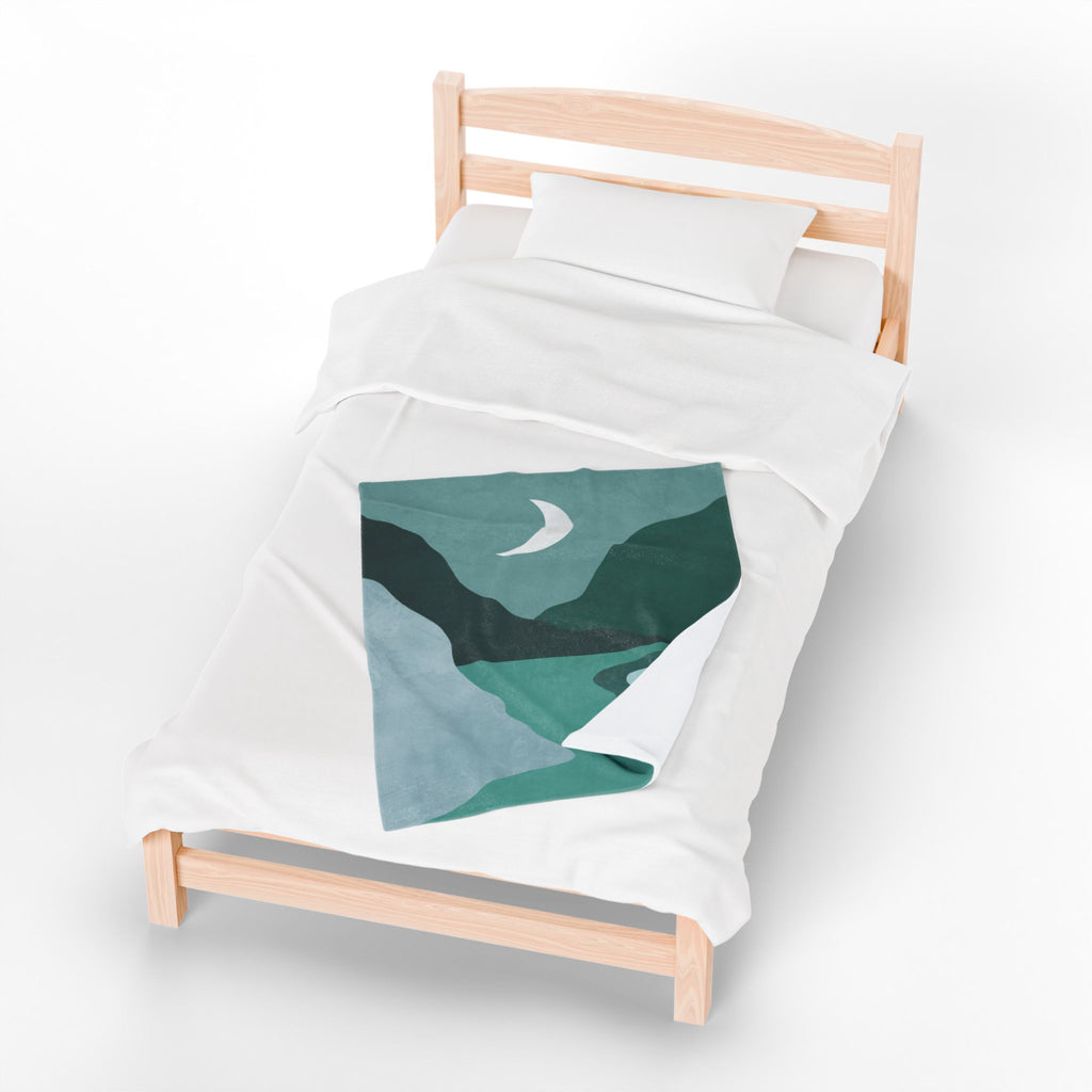 White duvet with with green abstract design lap blanket on it on a wooden bed frame against a white background