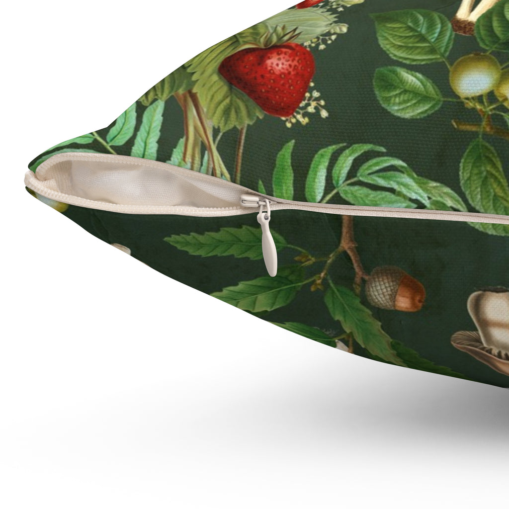 Pillow with nature-themed design featuring leaves, fruits, and a cup on a green background. Close of up the zipper detail on pillow.