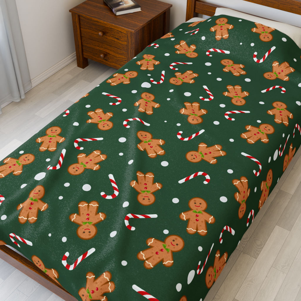 Throw blanket with gingerbread men and candy cane pattern on a green background