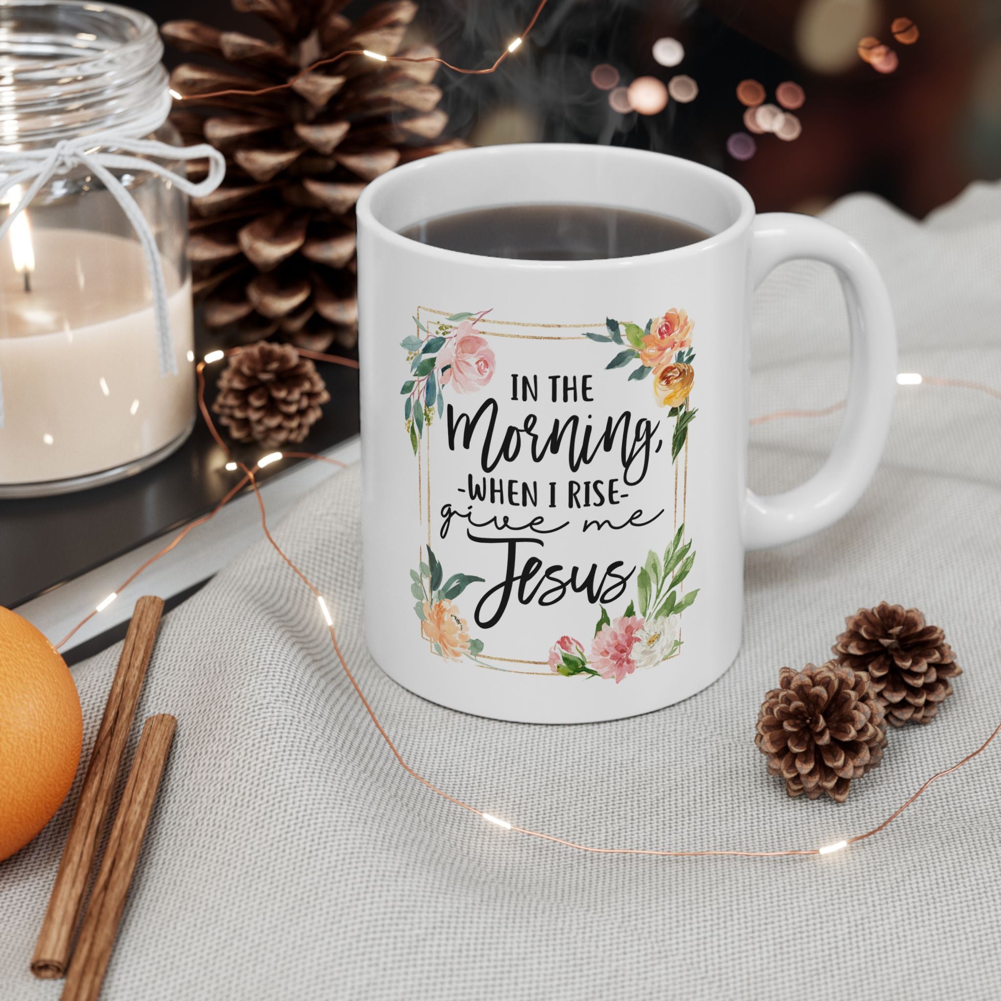 White mug with floral text design on a table with decorative items, Christian coffee mug