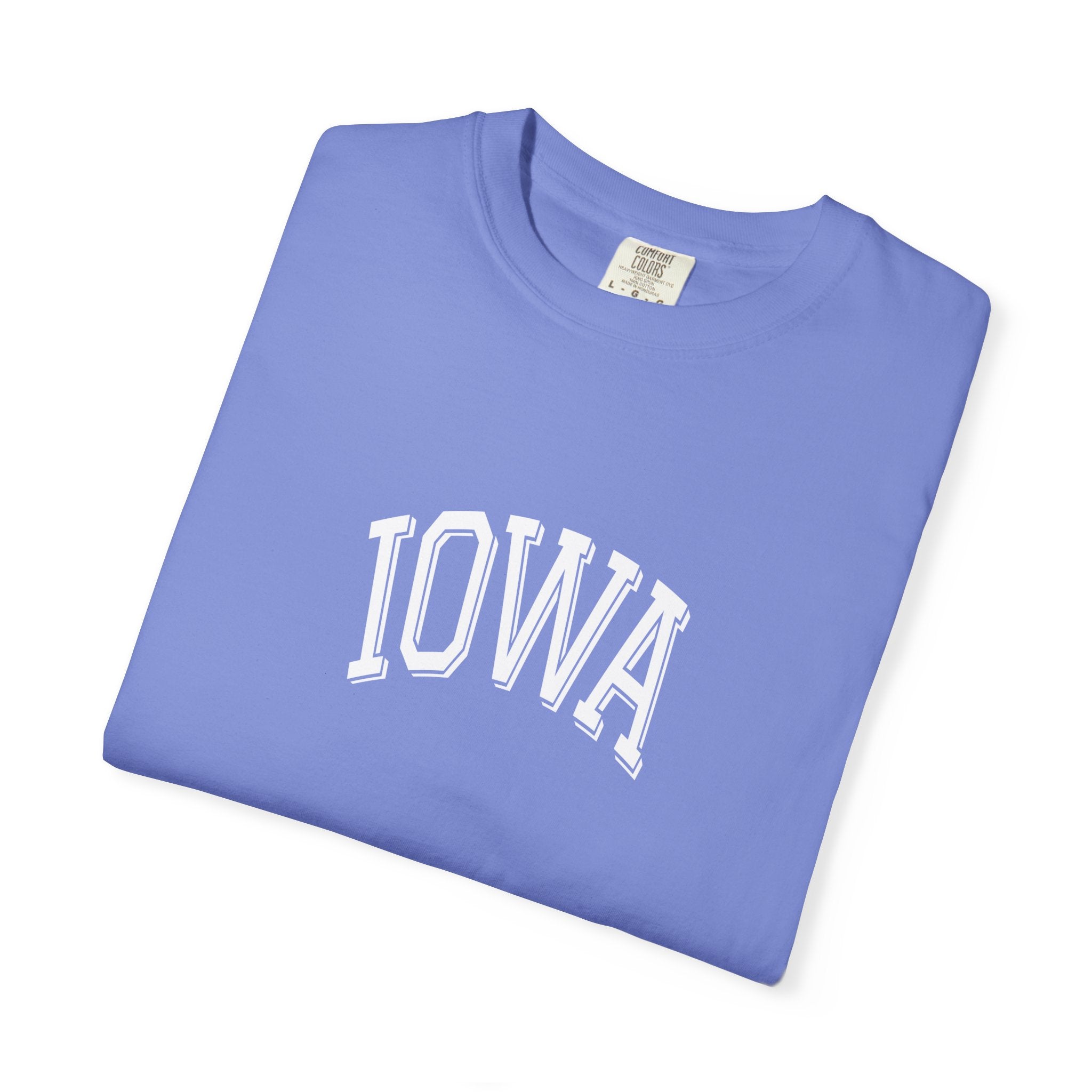 Folded flo blue Comfort Colors t-shirt with 'IOWA' print on a white background