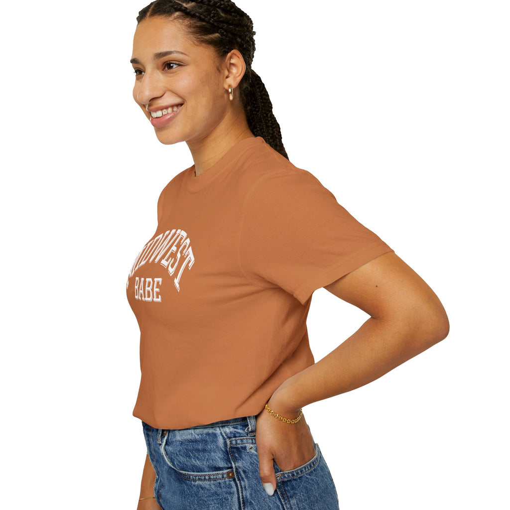 Woman wearing a Comfort Colors t-shirt in Yam with "MIDWEST BABE" text on a white background