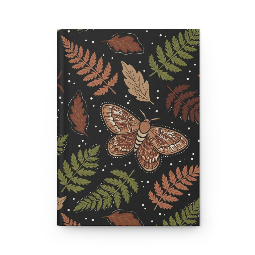 Black hardcover journal with a nature-inspired design featuring a detailed moth surrounded by ferns and autumn leaves in warm earthy tones.
