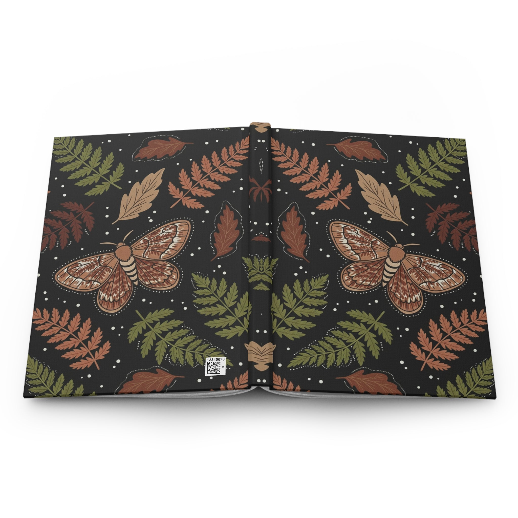 Open book with moth and fern leaf pattern on a white background