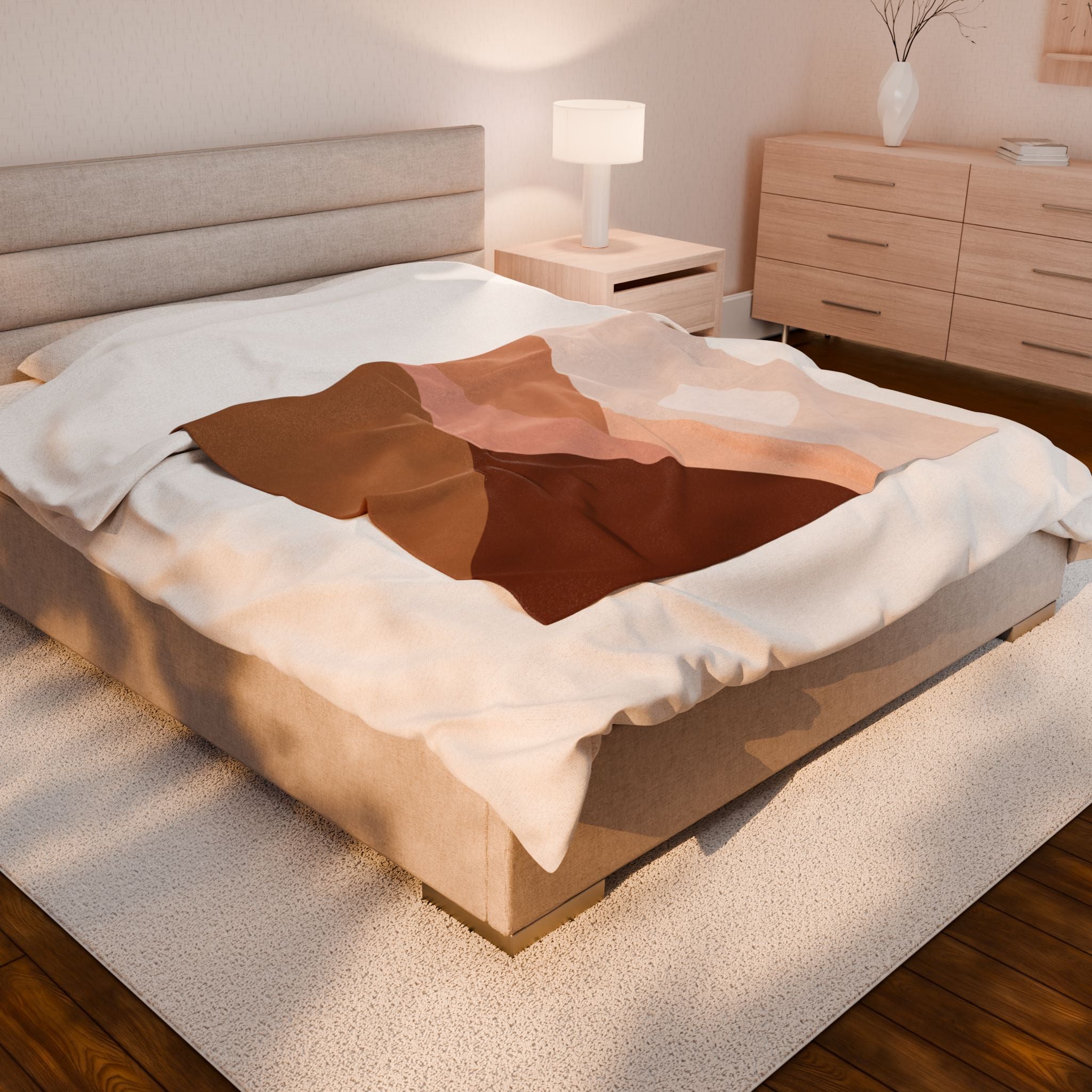 Bed with brown, beige and pink blush throw blanket in a bedroom setting