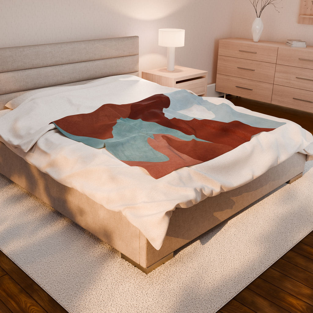 Bed with a abstract mountain scene throw blanket in a bedroom setting