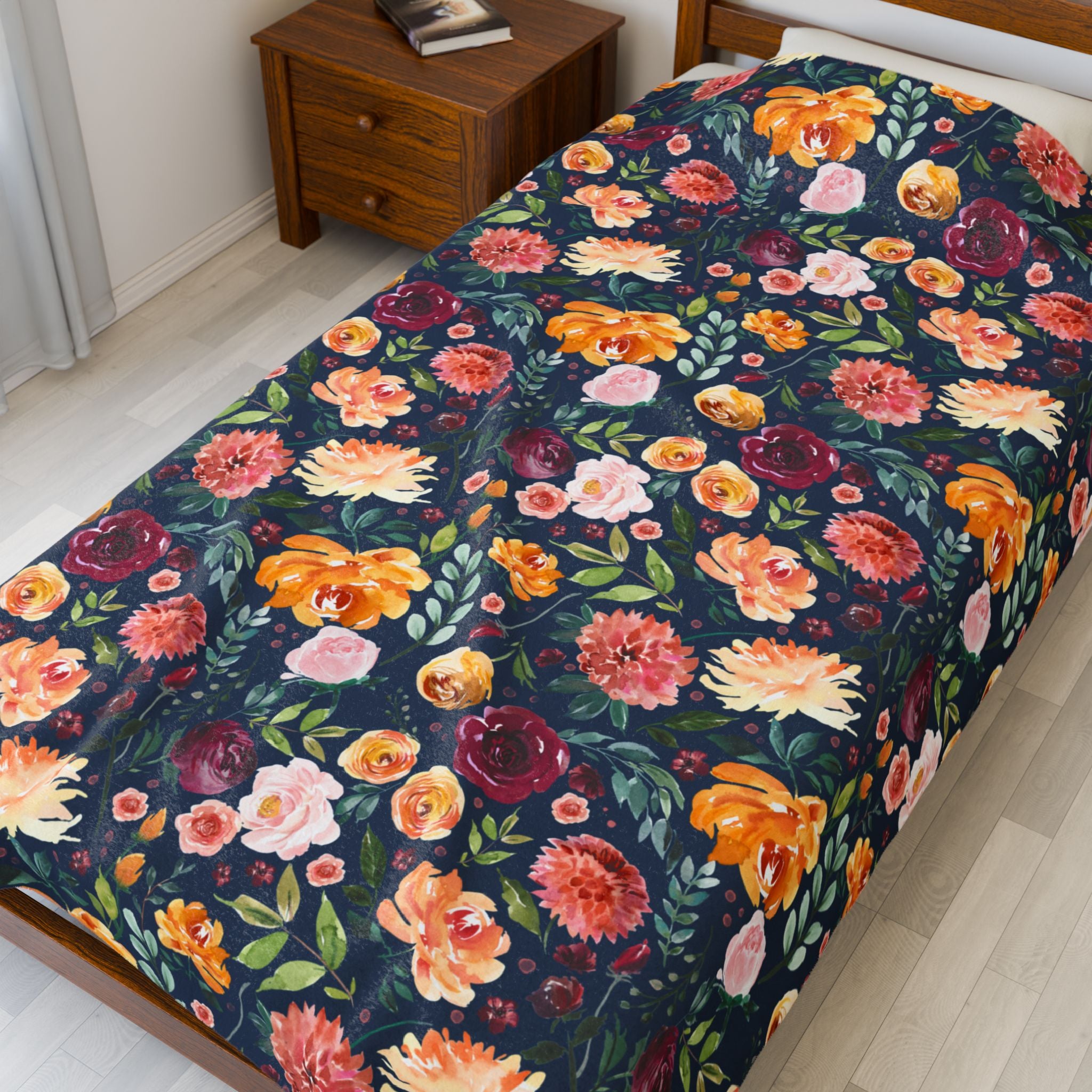 Floral patterned bedspread on a bed in a room with a wooden nightstand. boho floral bedding