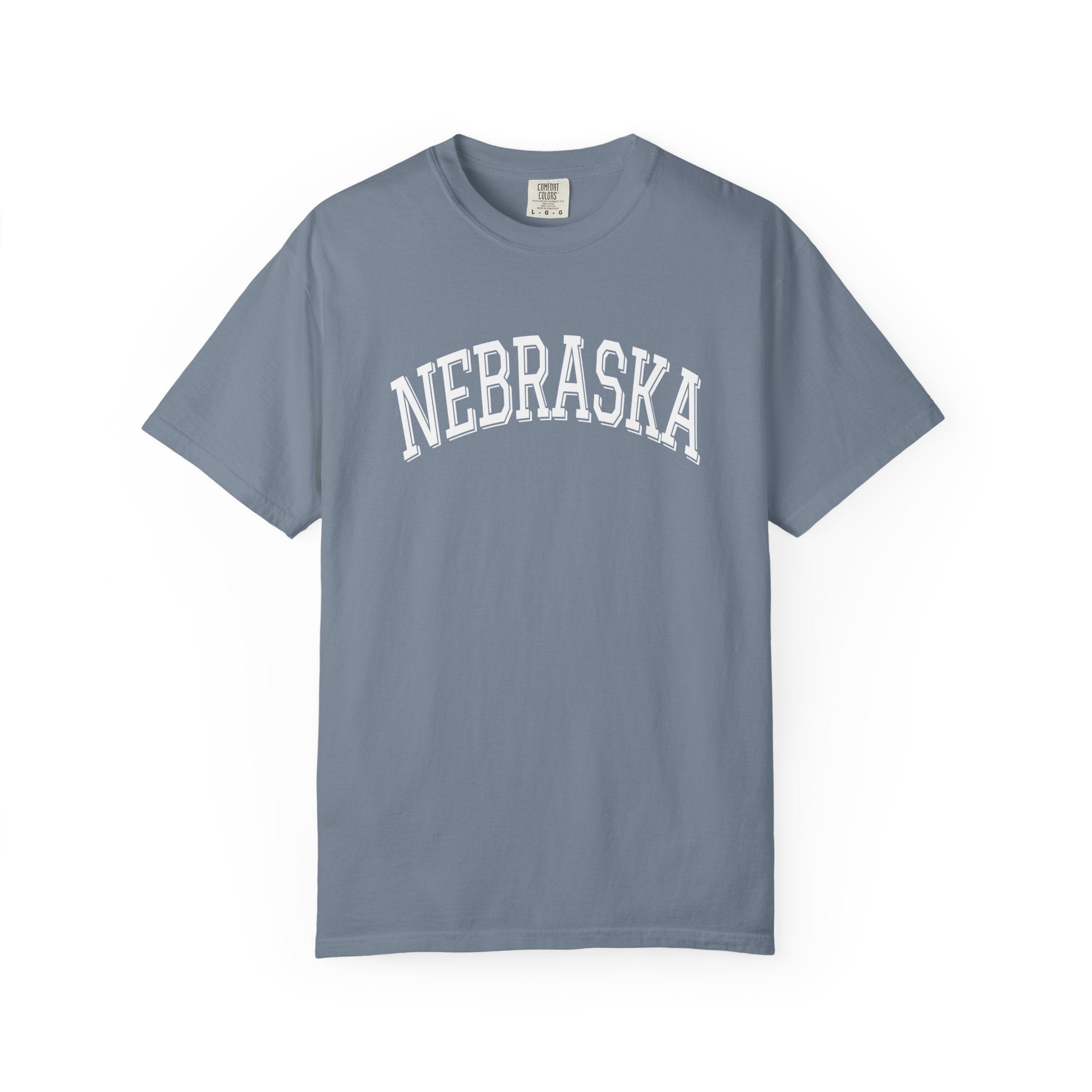 Comfort Colors Blue Jean t-shirt with 'NEBRASKA' printed on it against a white background