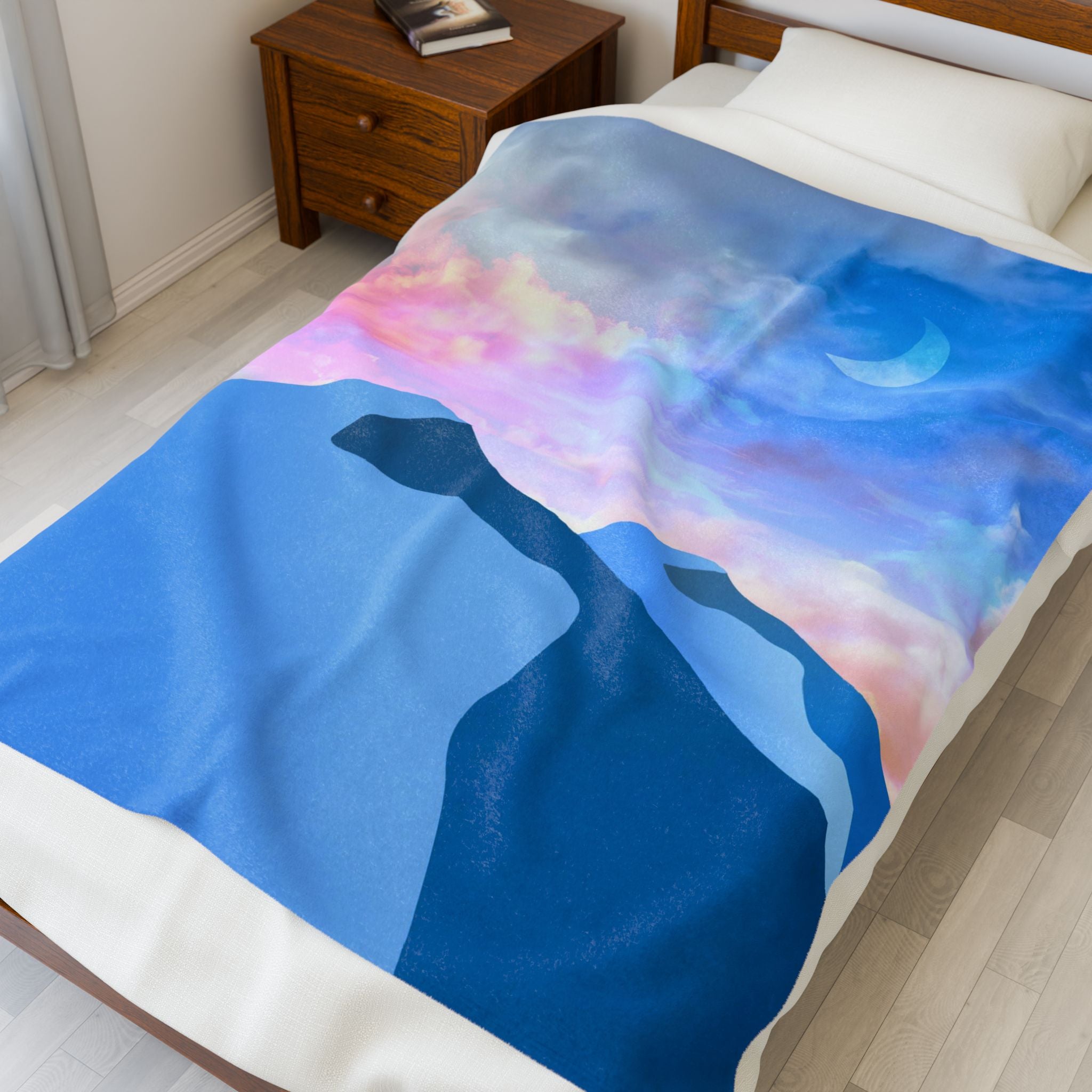 Bed with a colorful mountain scene blanket in a bedroom setting