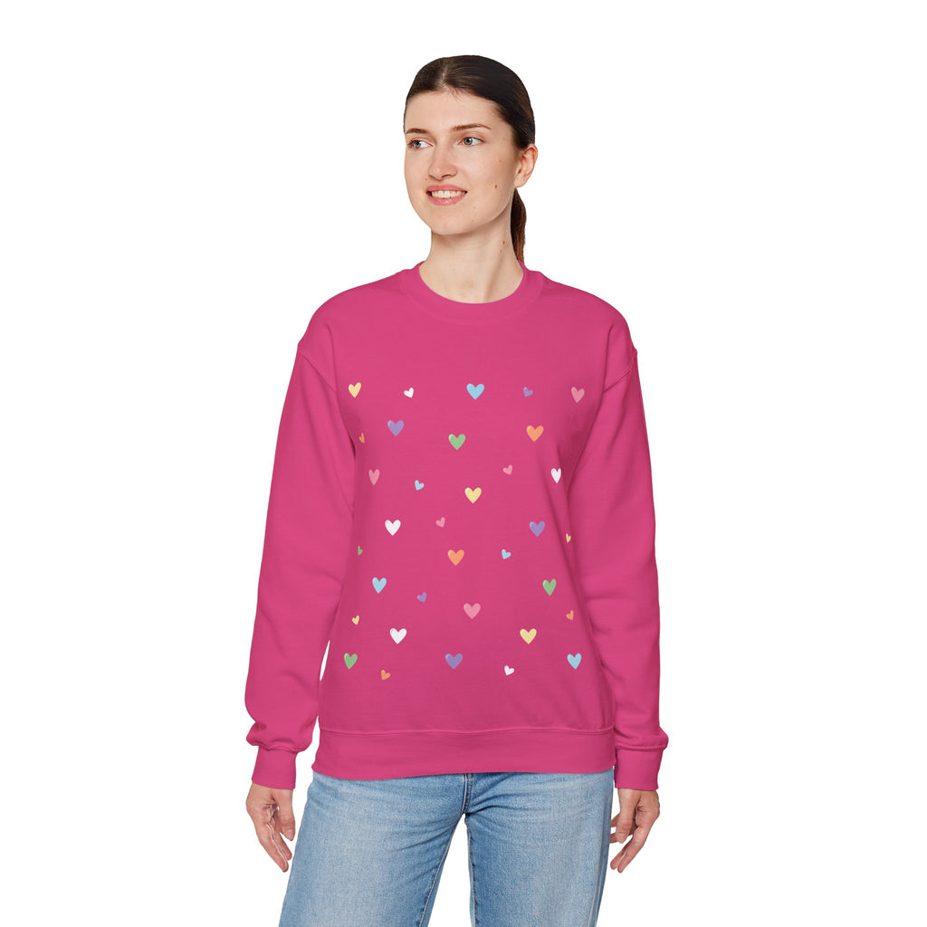 Woman wearing a heliconia pink sweatshirt with colorful heart patterns on a white background