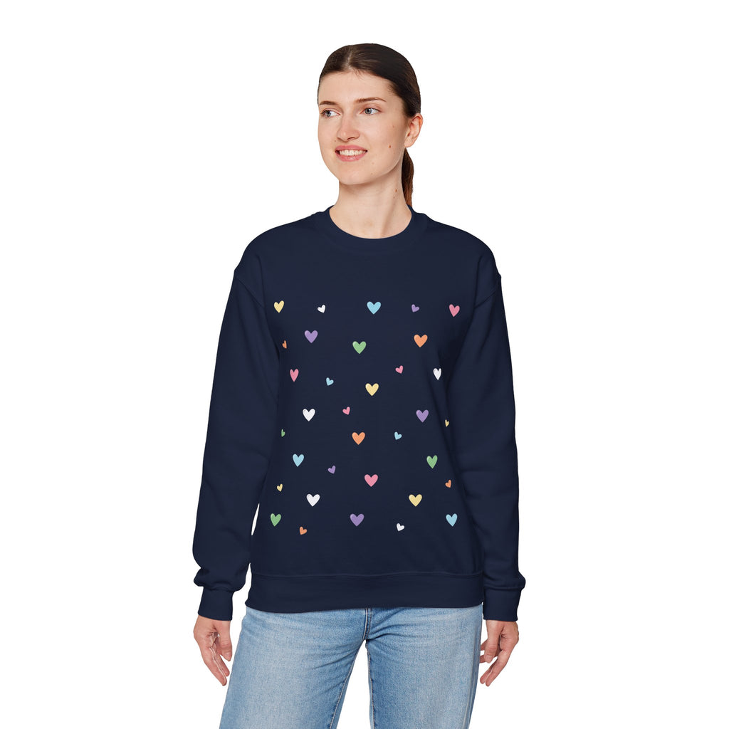 Woman wearing a navy blue sweatshirt with colorful heart patterns on a white background