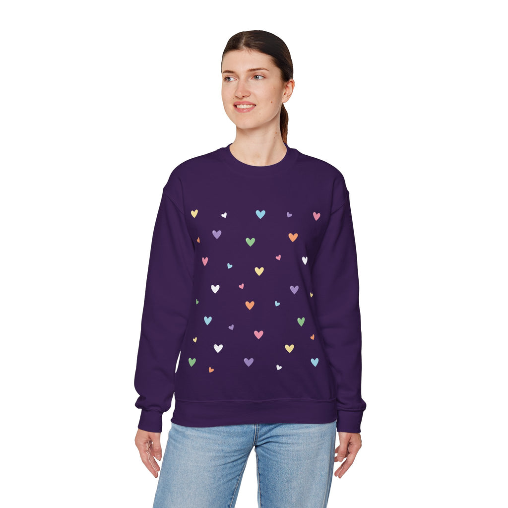 Woman wearing a purple sweatshirt with colorful pastel heart patterns on a white background