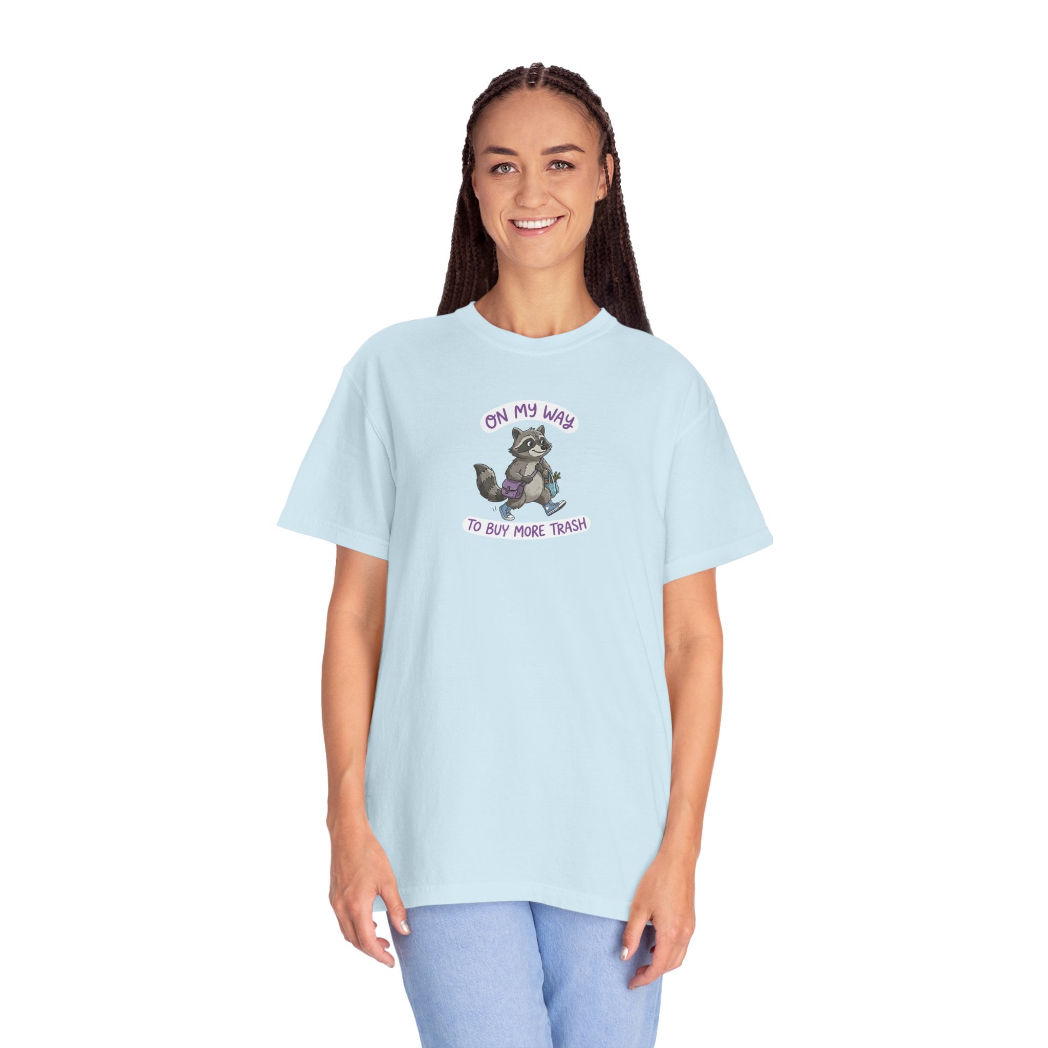 Woman wearing a light blue raccoon t-shirt with 'On My Way To Buy More Trash' text on a white background