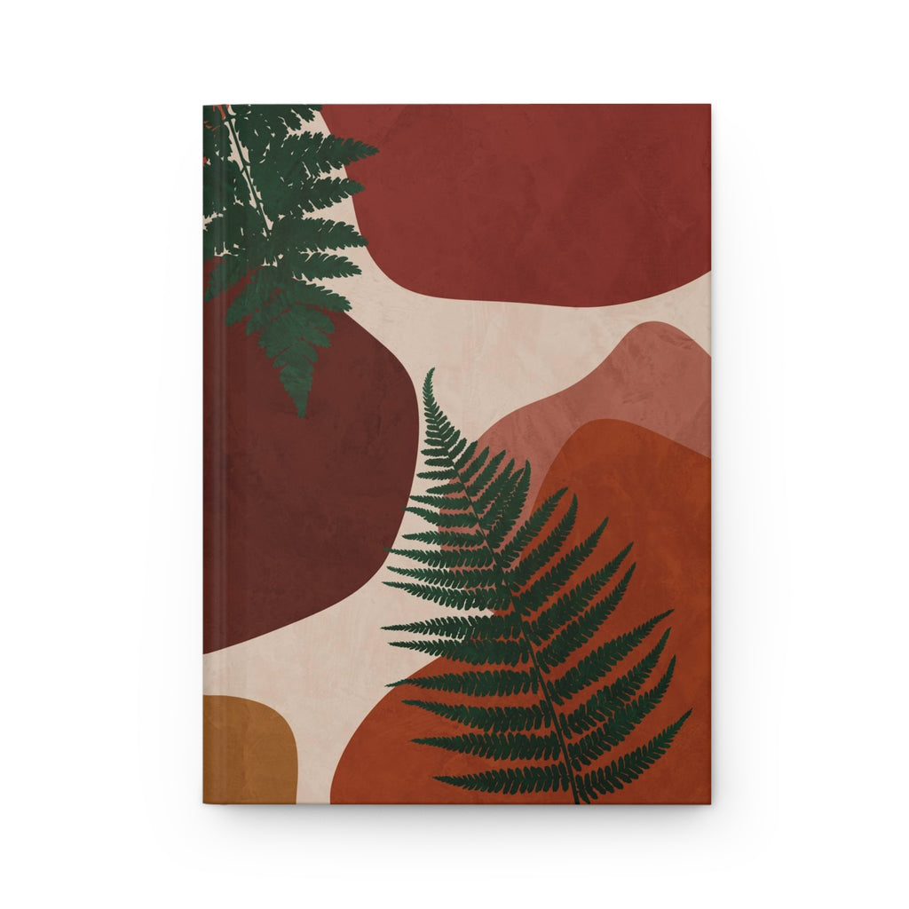 Geometric rust, orange, and burgundy shapes intersect with delicate fern leaves on a hard cover matte journal.