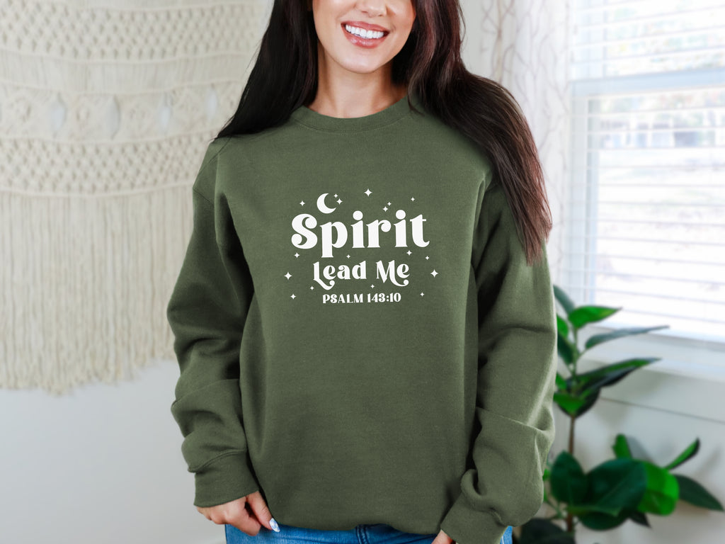 Person wearing a military green sweatshirt with 'Spirit Lead Me' text, standing indoors. Gildan 18000 sweatshirt, Bible verse sweatshirt