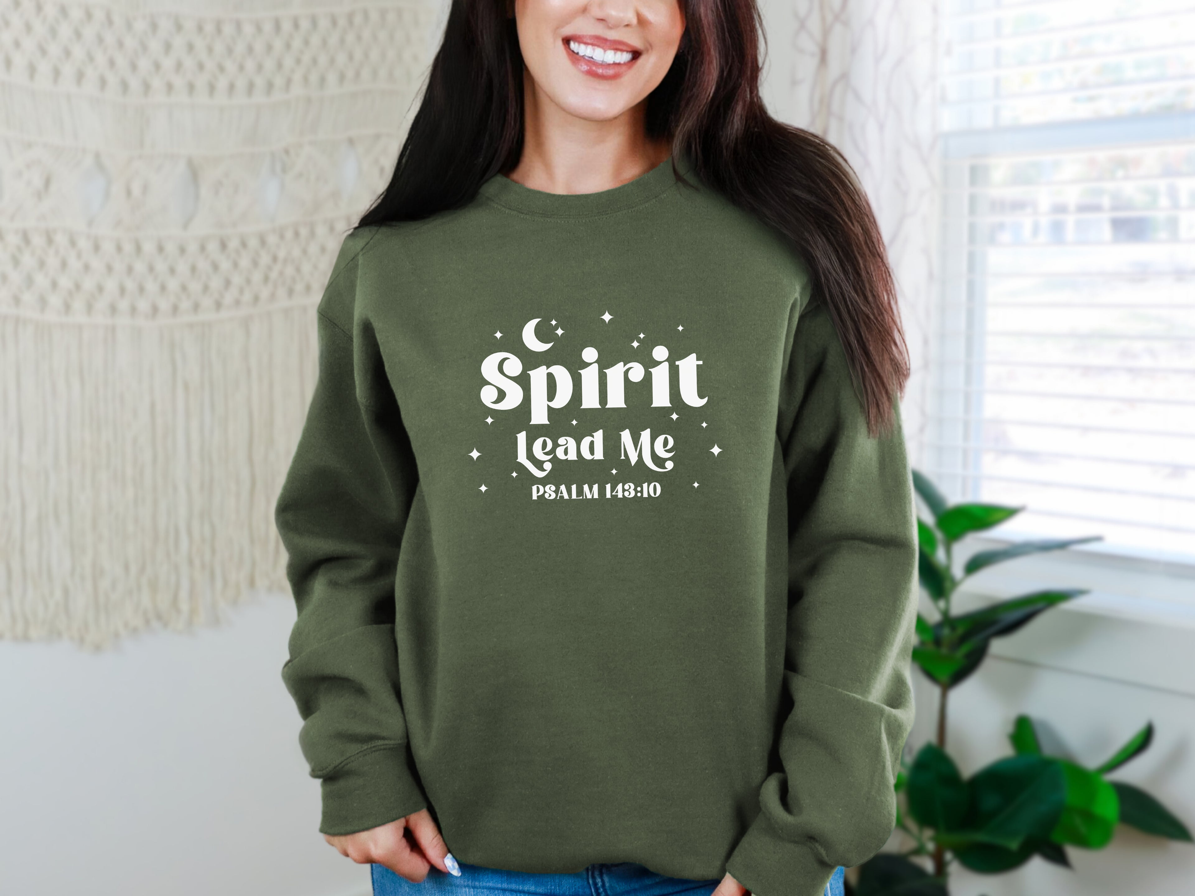 Person wearing a military green sweatshirt with 'Spirit Lead Me' text, standing indoors. Gildan 18000 sweatshirt, Bible verse sweatshirt
