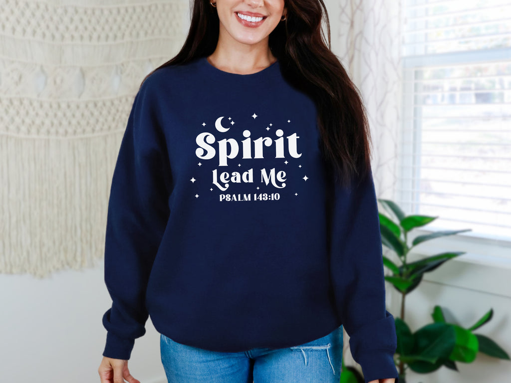 Woman wearing a navy blue sweatshirt with 'Spirit Lead Me' text in a home setting. Woman's sweatshirt with Bible verse on it.