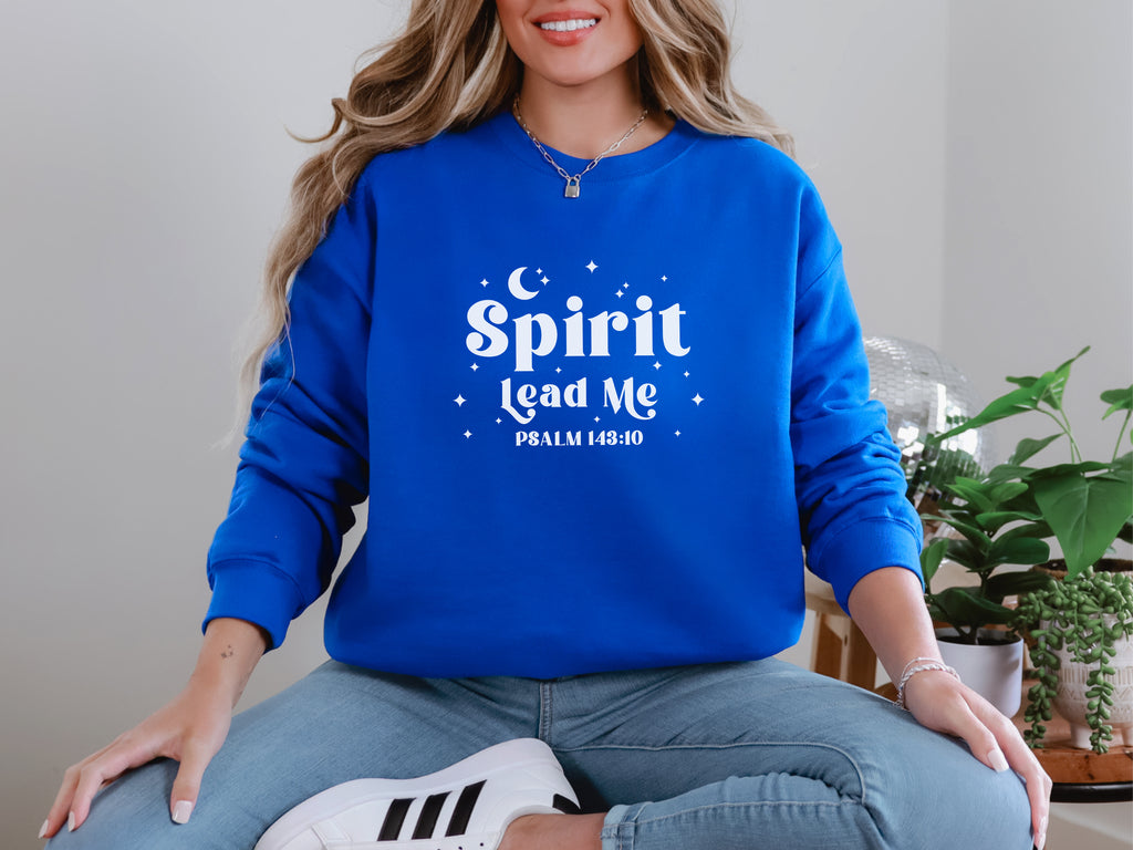 Person wearing a royal blue sweatshirt with 'Spirit Lead Me' text, sitting indoors. Psalm 143:10 bible verse sweatshirt