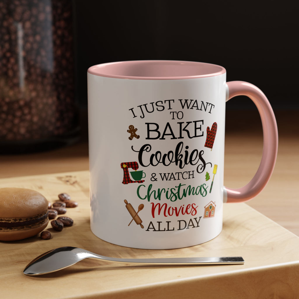 Pink Handle Mug with text 'I just want to bake cookies & watch Christmas movies all day' on a wooden surface with coffee beans and a spoon.