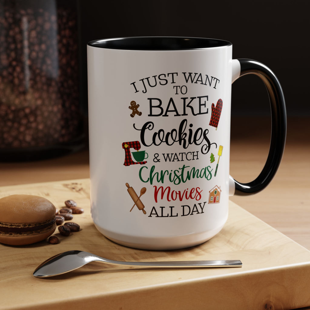 White mug with black interior and handle, featuring text and graphics on a wooden surface with cookies and a spoon.
